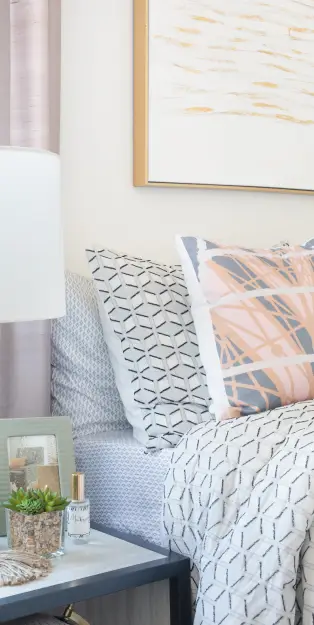 a bed next to a decorated nightstand