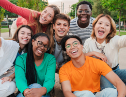 a group of young adults smiling outside